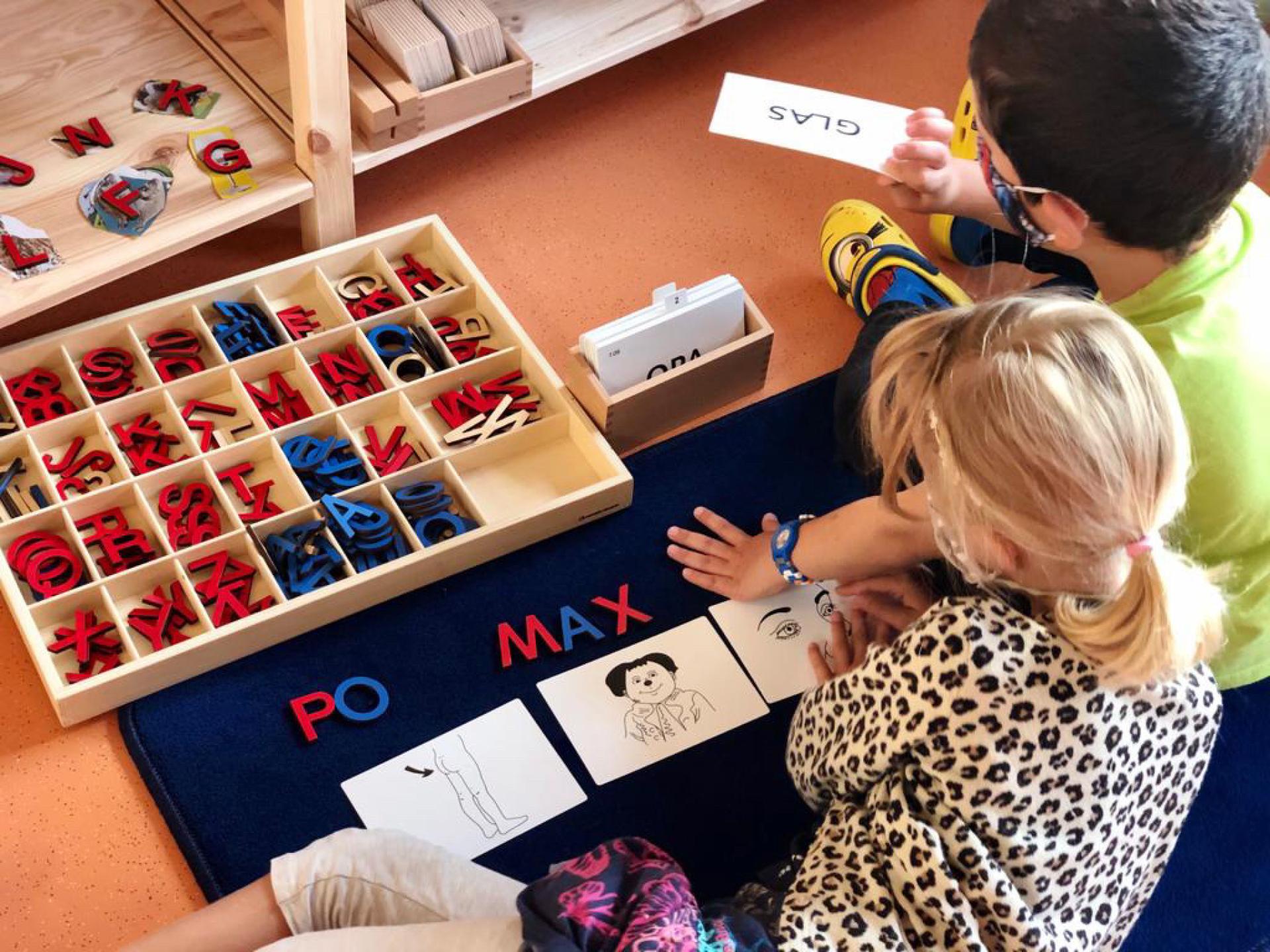 Zwei Kinder spielen mit Buchstaben in einem Klassenzimmer