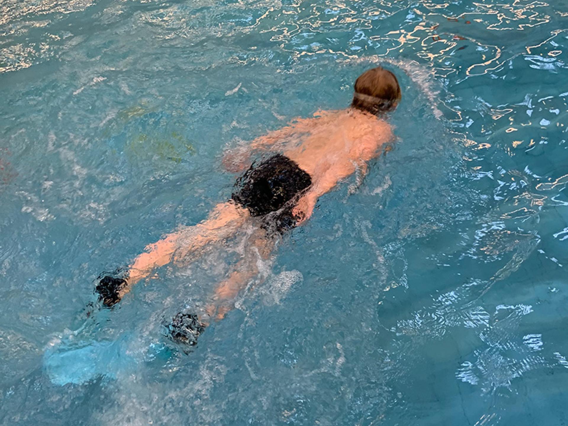 Ein Junge schwimmt im Pool