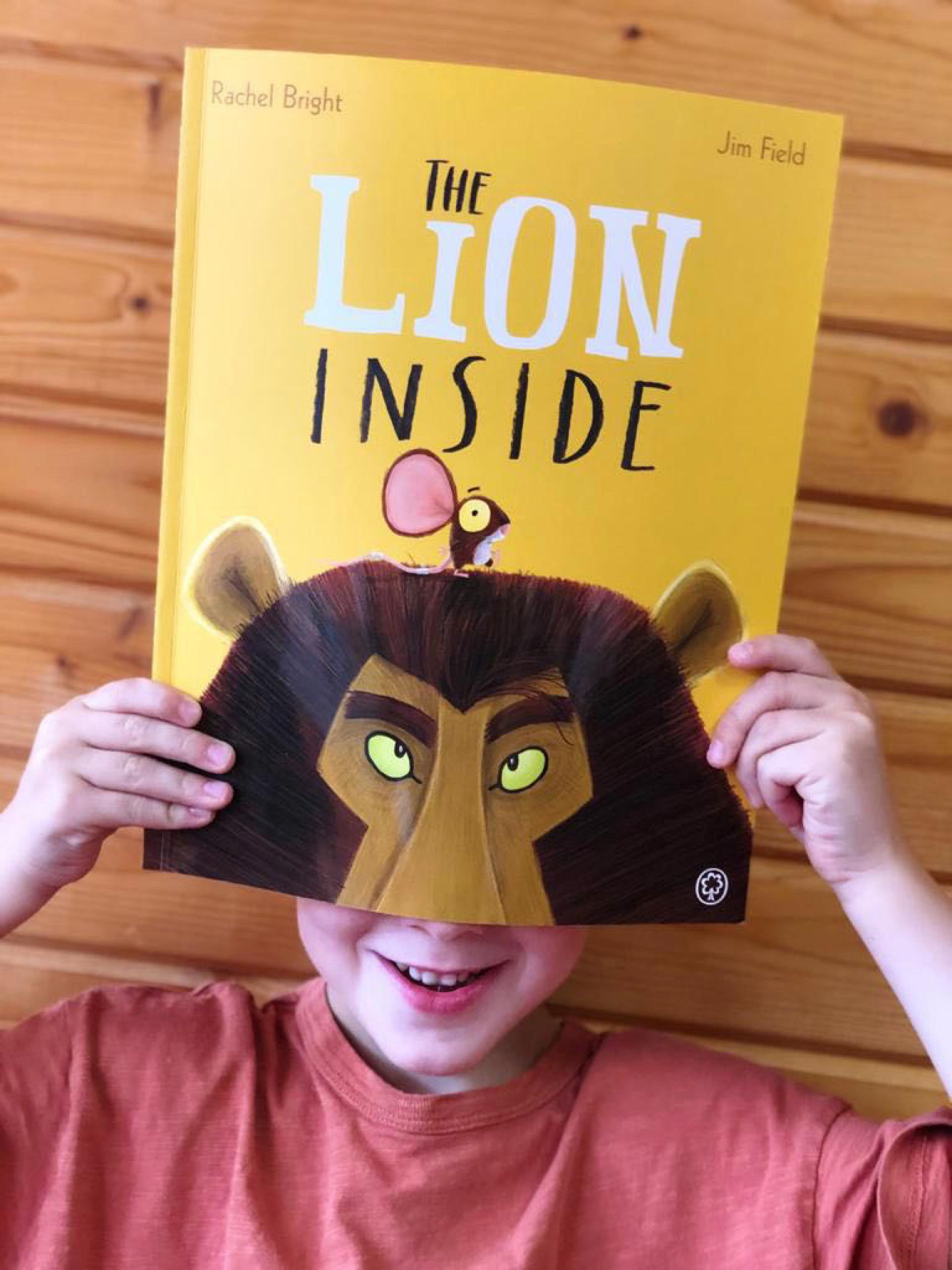 Ein Kind hält ein Buch mit einem Löwen auf dem Cover vor seinem Gesicht