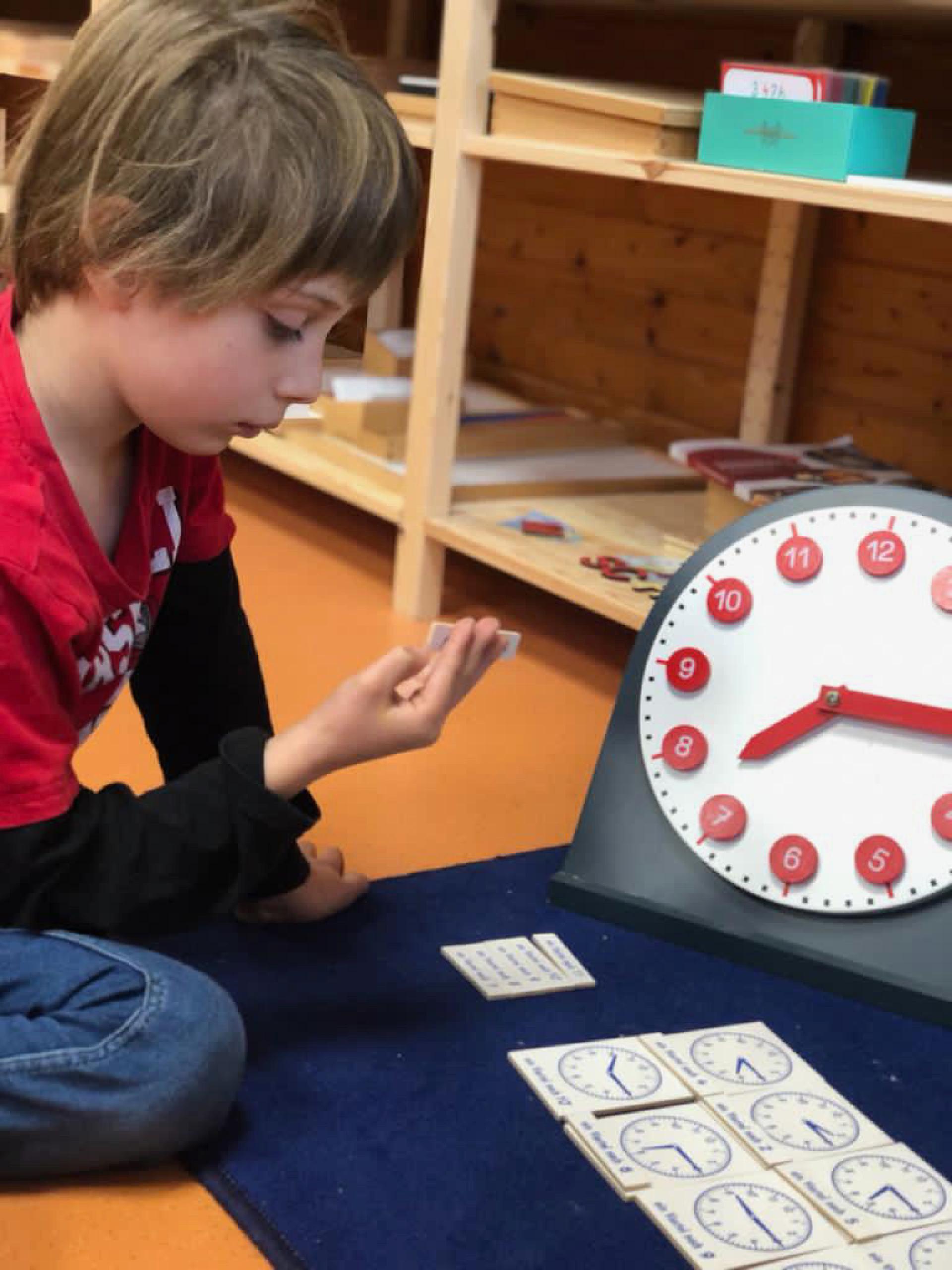 Ein Kind spielt mit einer Uhr und erkundet die Zeit auf spielerische Weise
